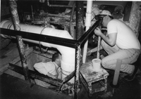 Ray Appleby in pit helping student get measurement during student paper machine run
